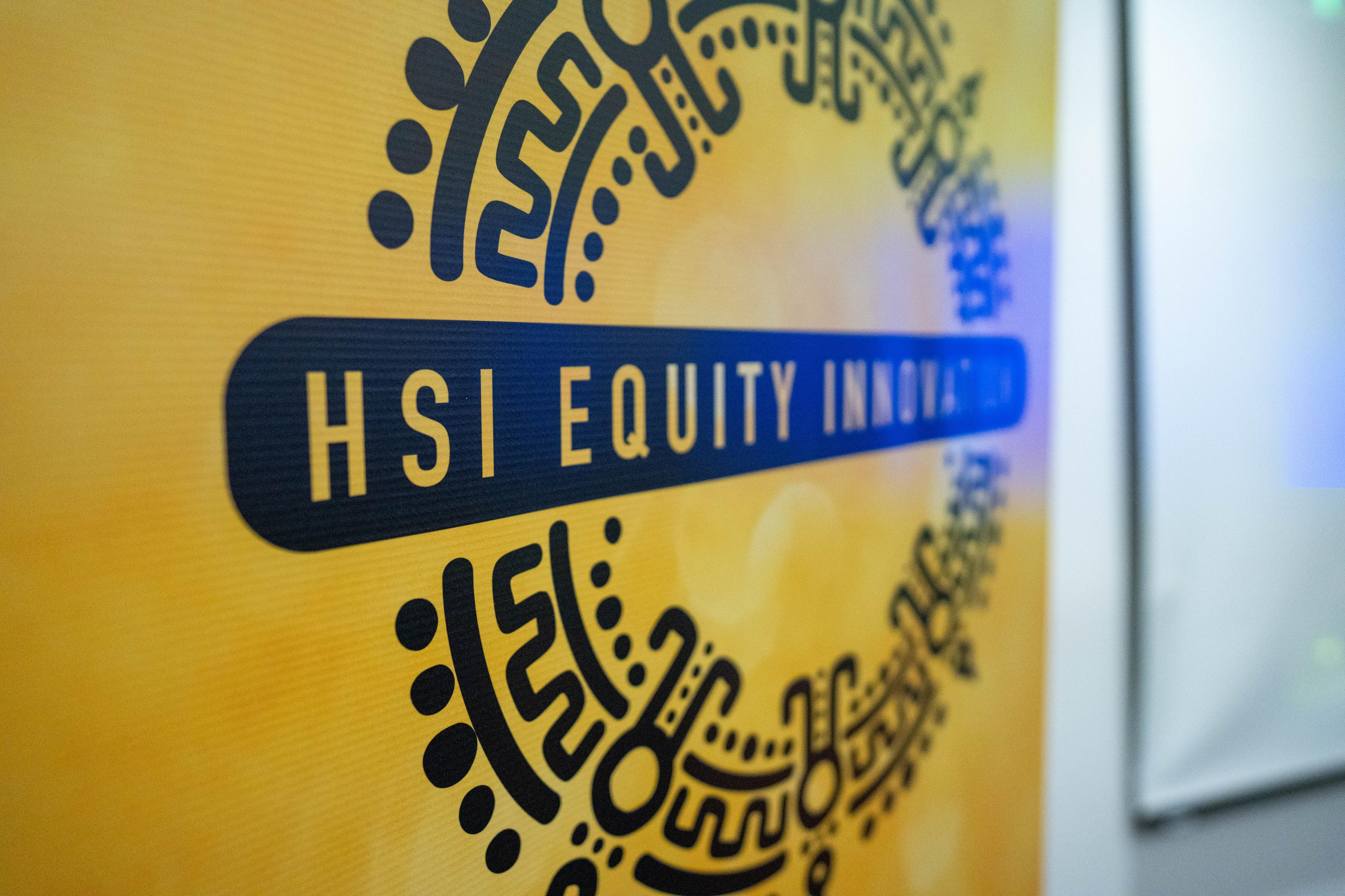 Close-up of the HSI Equity Innovation logo on a yellow event banner.